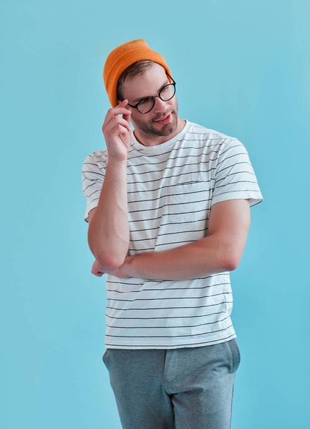 Handsome man isolated. Stylish young man in eyeglasses is  posing on blue background. - Photo, image