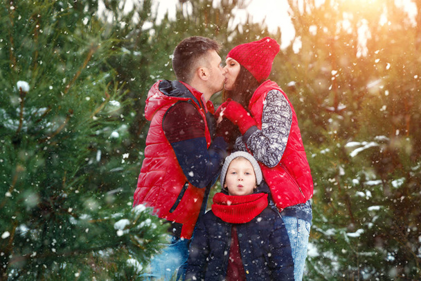 Happy family in warm clothes in the winter outdoors. Concept of holidays, holidays, winter, new year, day of grace. Family relationships, happy marriage. - Foto, Imagen