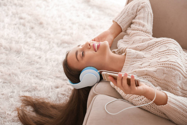 mooie jonge vrouw luisteren naar muziek thuis - Foto, afbeelding