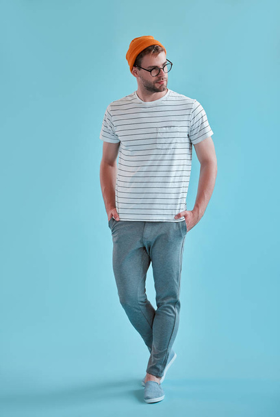 Handsome man isolated. Stylish young man in eyeglasses is  posing on blue background. - Fotoğraf, Görsel