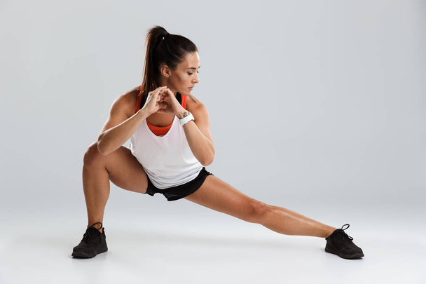 Image of amazing young sports woman make stretching exercises isolated indoors. - Foto, Imagem