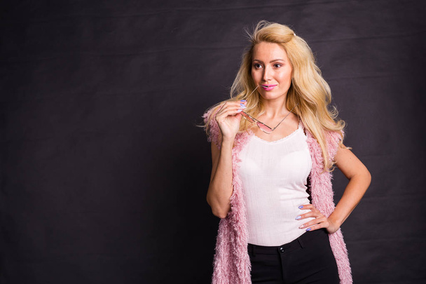 Mode- und Schönheitskonzept - schönes blondes Model posiert vor dunklem Hintergrund mit Kopierraum - Foto, Bild