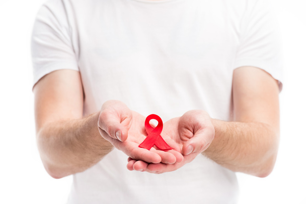 cropped image of man showing red ribbon in hands isolated on white, world aids day concept - Zdjęcie, obraz