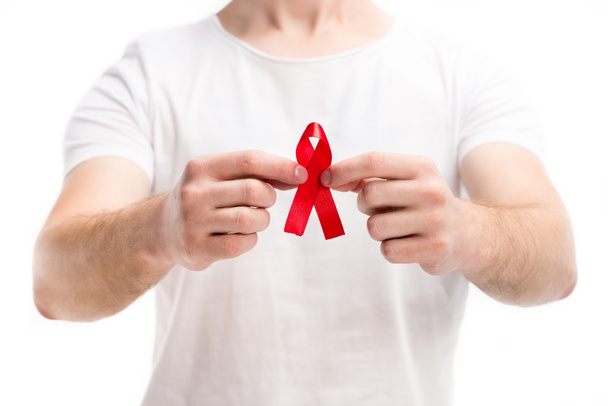 cropped image of man in white shirt showing red ribbon isolated on white, world aids day concept - Foto, afbeelding
