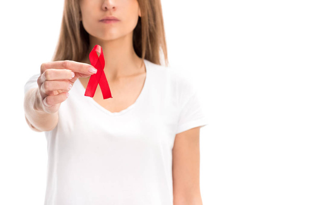 cropped image of woman in white shirt showing red ribbon isolated on white, world aids day concept - Foto, Imagen