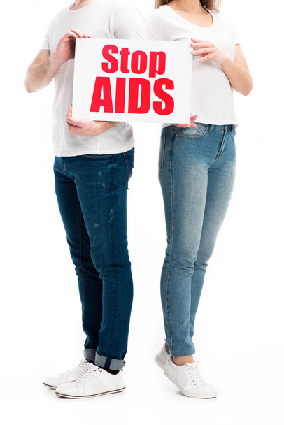körülvágott kép a heteroszexuális pár gazdaság kártya a stop aids szöveg elszigetelt fehér alkalmi ruhák - Fotó, kép