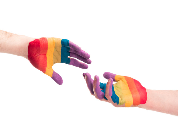 imagen recortada de pareja gay alcanzando manos pintadas en colores de la bandera del orgullo aislado en blanco, el mundo SIDA concepto del día
 - Foto, Imagen