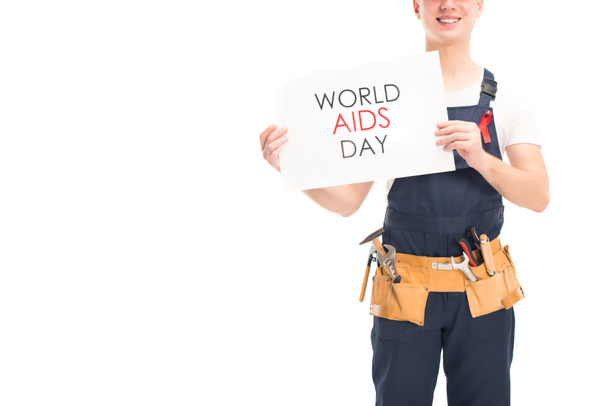 imagen recortada del trabajador sonriente en uniforme y cinta roja que muestra la tarjeta con el texto del día del sida mundial aislado en blanco
 - Foto, imagen