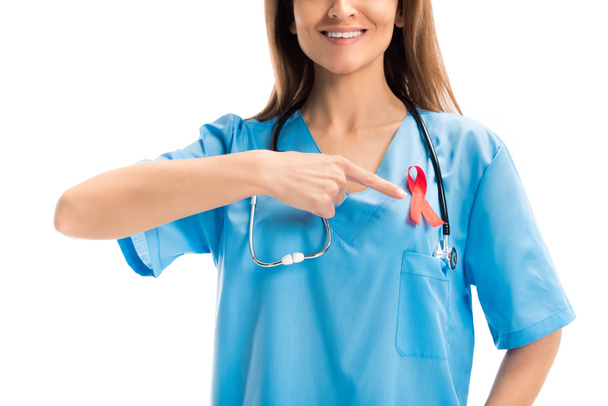 cropped image of smiling doctor pointing on red ribbon isolated on white, world aids day concept - Фото, зображення