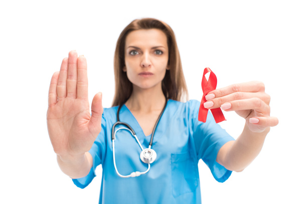 atrakcyjne lekarz trzyma czerwoną wstążką i Wyświetlono stop gest na białym tle na biały, koncepcja dnia aids świata - Zdjęcie, obraz