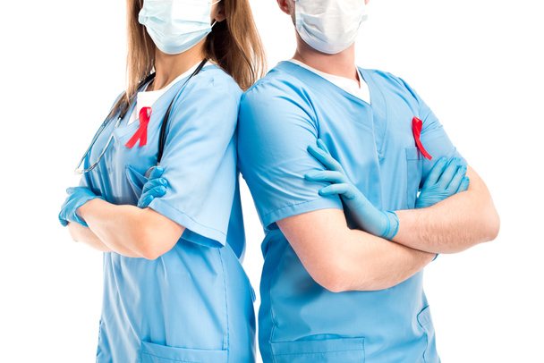кадроване зображення лікарів з червоними стрічками і маски медичні стоячи з схрещеними руками, ізольовані на білому світі СНІДу день концепції - Фото, зображення