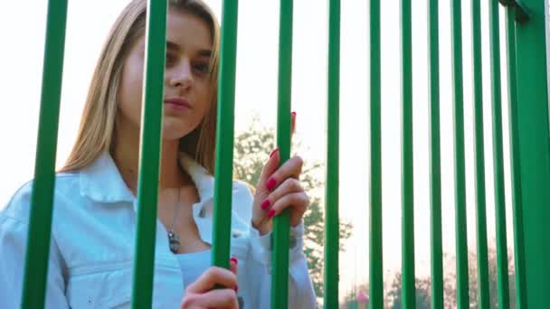junges Mädchen blickt durch das Gitter - Filmmaterial, Video