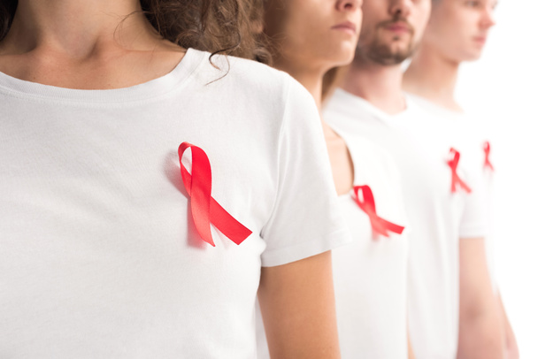 cropped image of people standing with red ribbons on white shirts isolated on white, world aids day concept - Foto, afbeelding