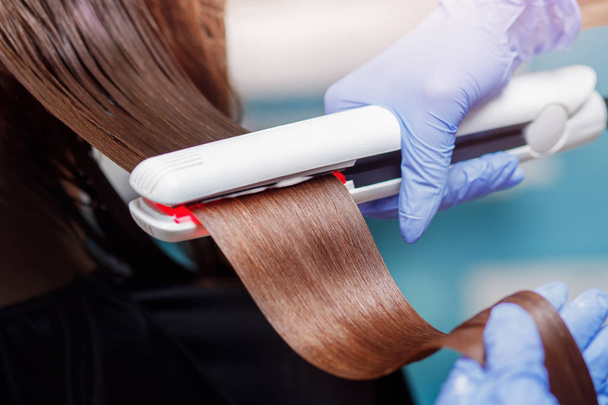 Кератиновое восстановление волос и протеиновое лечение с помощью профессионального ультразвукового железа - Фото, изображение