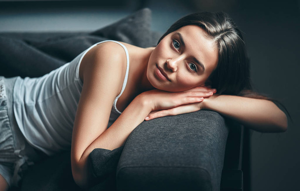 Good morning! Attractive young woman is having rest at home. Girl lying on a sofa. - Foto, Bild
