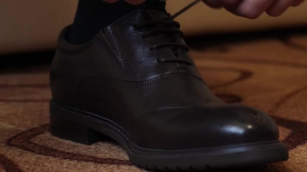 Männerhände binden Schnürsenkel an schwarzen Schuhen, Nahaufnahme - Filmmaterial, Video