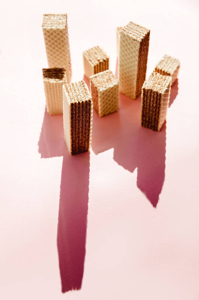 Creative minimalist picture of waffles cookies looks like skyscraper on pink background. - Photo, image