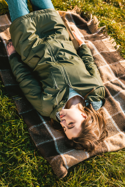 high angle view of young woman sleeping on blanket outdoors  - Фото, зображення