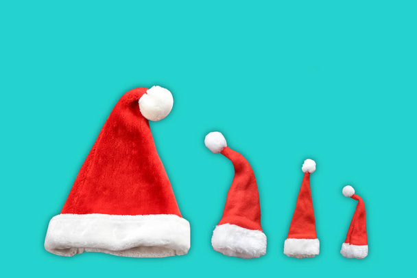 Christmas background. Minimal. Winter holiday arrives. Funny Santa Claus hats isolated over blue background. Pop art - Photo, Image