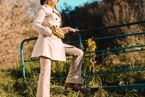 partial view of elegant stylish woman in trench coat posing outdoors  - Fotó, kép