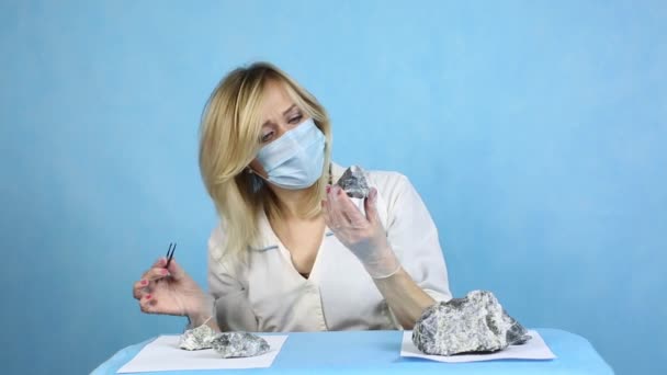 The girl laboratory technician examines samples of minerals.A woman lab worker examines the stones with tweezers takes the fibers of harmful asbestos. - Footage, Video