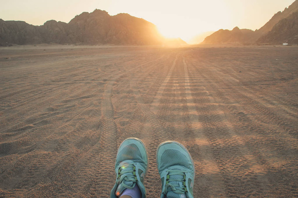Aavikko Egyptissä. Sharm el Sheikh (s. Sand ja Sand Borkhan. Kivi ja auringonlasku. Naisten jalat lenkkareissa. Tytön jalat
 - Valokuva, kuva