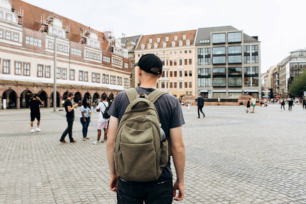 Turista con mochila en Leipzig admirando hermosos edificios
. - Foto, Imagen