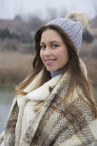 Una giovane ragazza con un cappello caldo e sciarpa a piedi
 - Foto, immagini