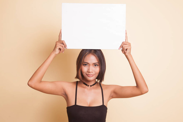Young Asian woman with white blank sign on beige background - Fotoğraf, Görsel