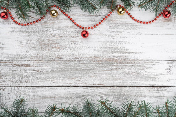 Xmas card. Oude houten Kerstmis achtergrond. Spar takken. Gouden en rode kerstballen. Rode slingers. Bovenaanzicht. Ruimte voor uw tekst. - Foto, afbeelding