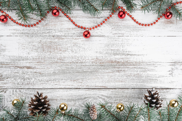 Old wooden Christmas background. Fir branches and cones. Gold and red baubles and garlands. Top view. Space for your text. Xmas card. - Photo, Image