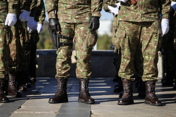 Szczegóły z mundury, rękawice, buty i pistolety żołnierzy przebywających w kolejce - Zdjęcie, obraz