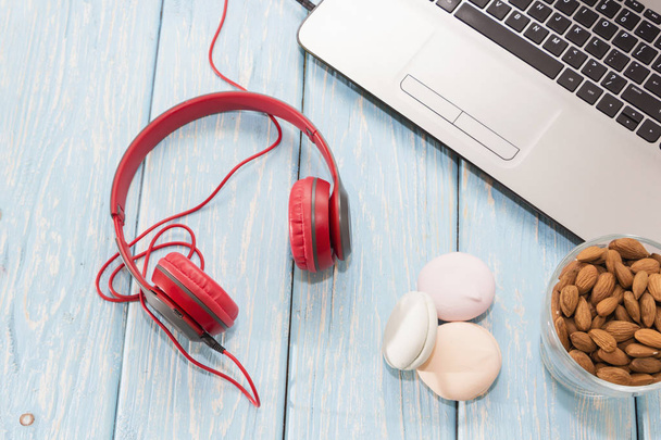 Laptop and red headphones on a light background, almonds and marshmallows. laptop in the background. - 写真・画像