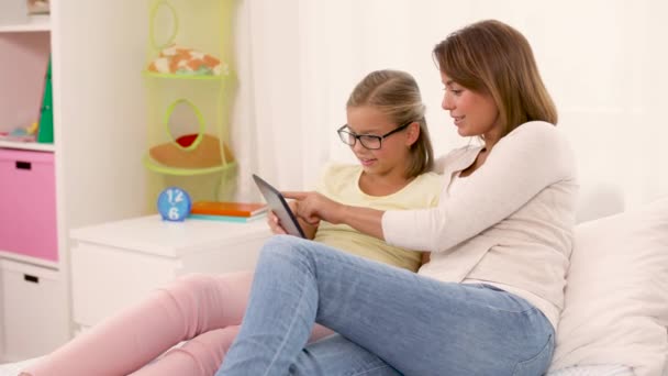 happy mother and daughter with tablet pc at home - Materiał filmowy, wideo