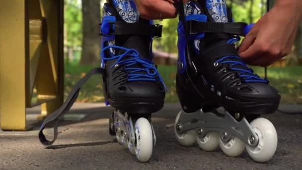 Woman putting on roller skates in park - Footage, Video