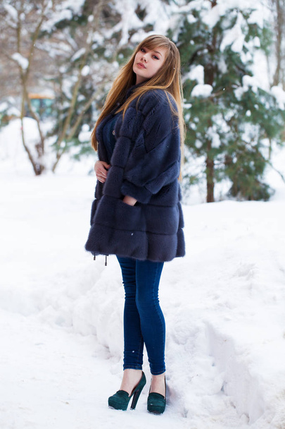 Full length portrait of young beautiful elegant brunette woman wearing fur coat. Fashionable girl walking at the street at winter. - Фото, зображення
