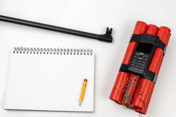 A notepad for making notes and a pencil on a table with a firearm. Shooting accessories and materials for quotation. White background. - Photo, image
