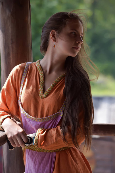 young vikig girl in orange dress - 写真・画像