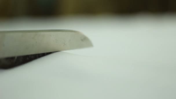 men's hand with scissors cutting white textile material - Felvétel, videó