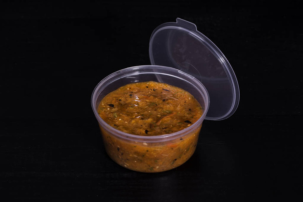 Sauce aux légumes dans un plat en plastique sur table noire
 - Photo, image