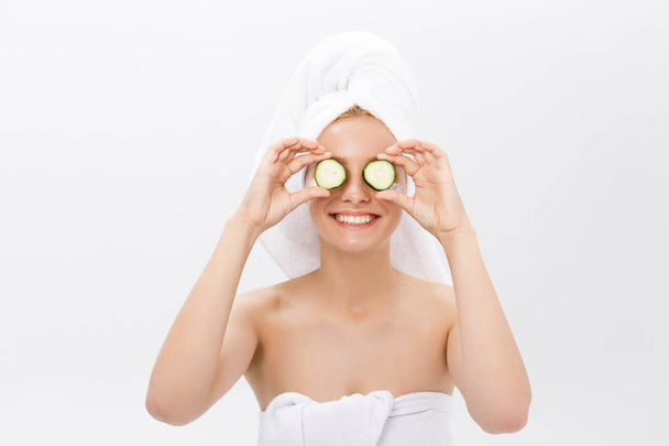 Beautiful woman holding slices of cucumber in front of her eyes - Foto, immagini