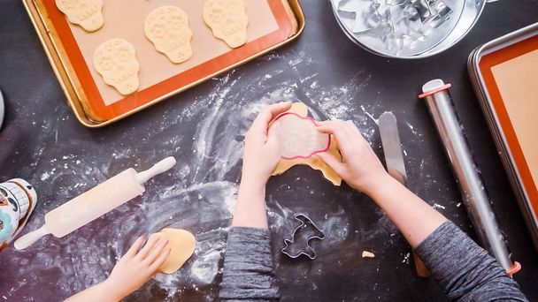 Flat lay. Mother and daughter baking sugar skull cookies for Dia de los Muertos holiday. - Photo, Image