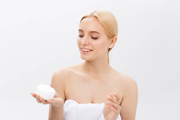 beautiful model applying cosmetic cream treatment on her face on white - Фото, зображення