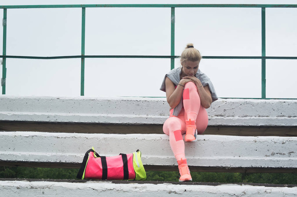 Girl athlete resting after training at the stadium - Photo, Image