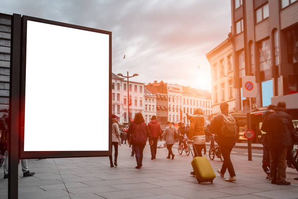 Vertical blank billboard in the city center with Mock up. The layout is located in a crowded street with people. - Photo, Image