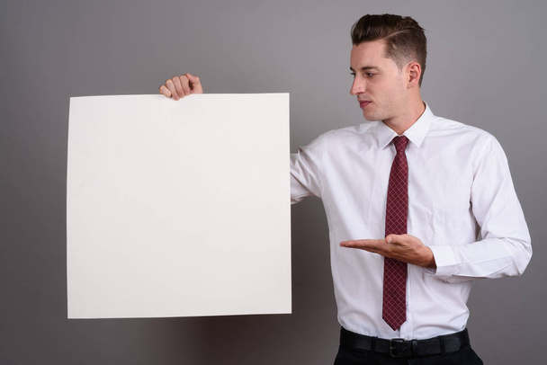 Biznesmen, trzymając pusty biały deska z miejsca kopii - Zdjęcie, obraz