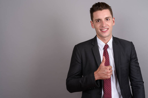 Young handsome businessman smiling and giving thumb up - Foto, immagini