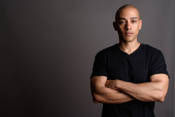 Handsome bald man wearing black shirt with arms crossed - Photo, Image