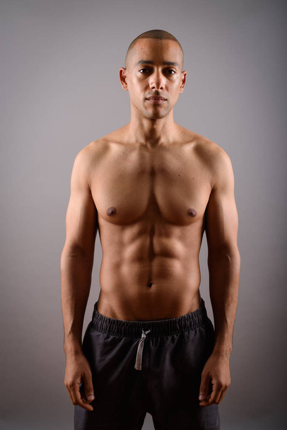 Handsome bald man with six pack abs against gray background - Foto, Imagem