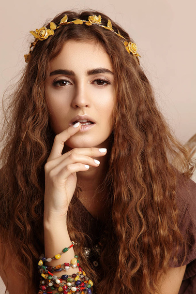 Beautiful Woman. Curly Long Hair. Fashion Model with Healthy Wavy Hairstyle. Accessories. Boho Girl with Autumn Wreath, Gold Floral Crown. Vertical shot - Photo, Image
